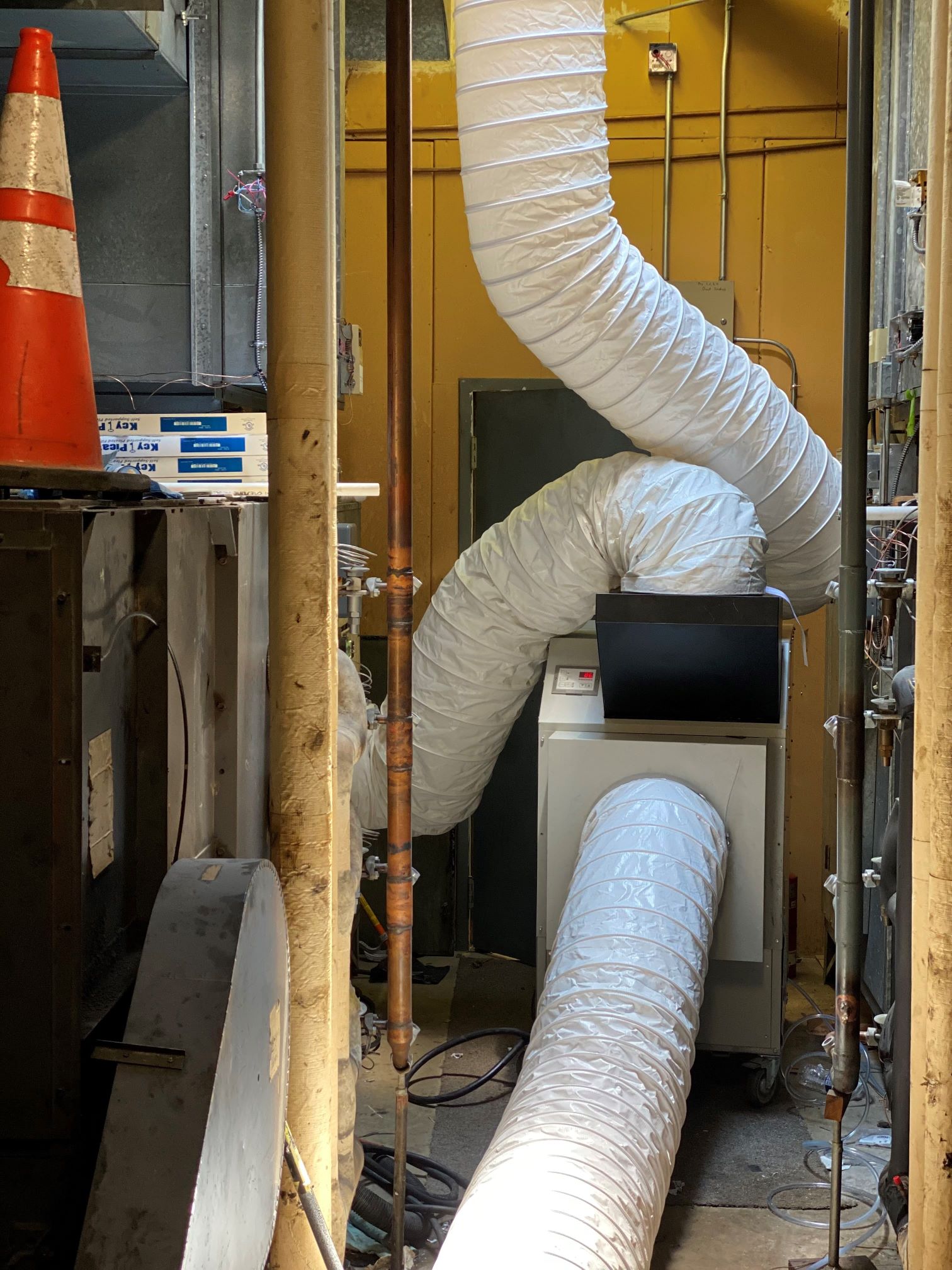 A mechanical room of a commercial building with an AC rental ducted to the building air handler distributing cool air to the office space. 