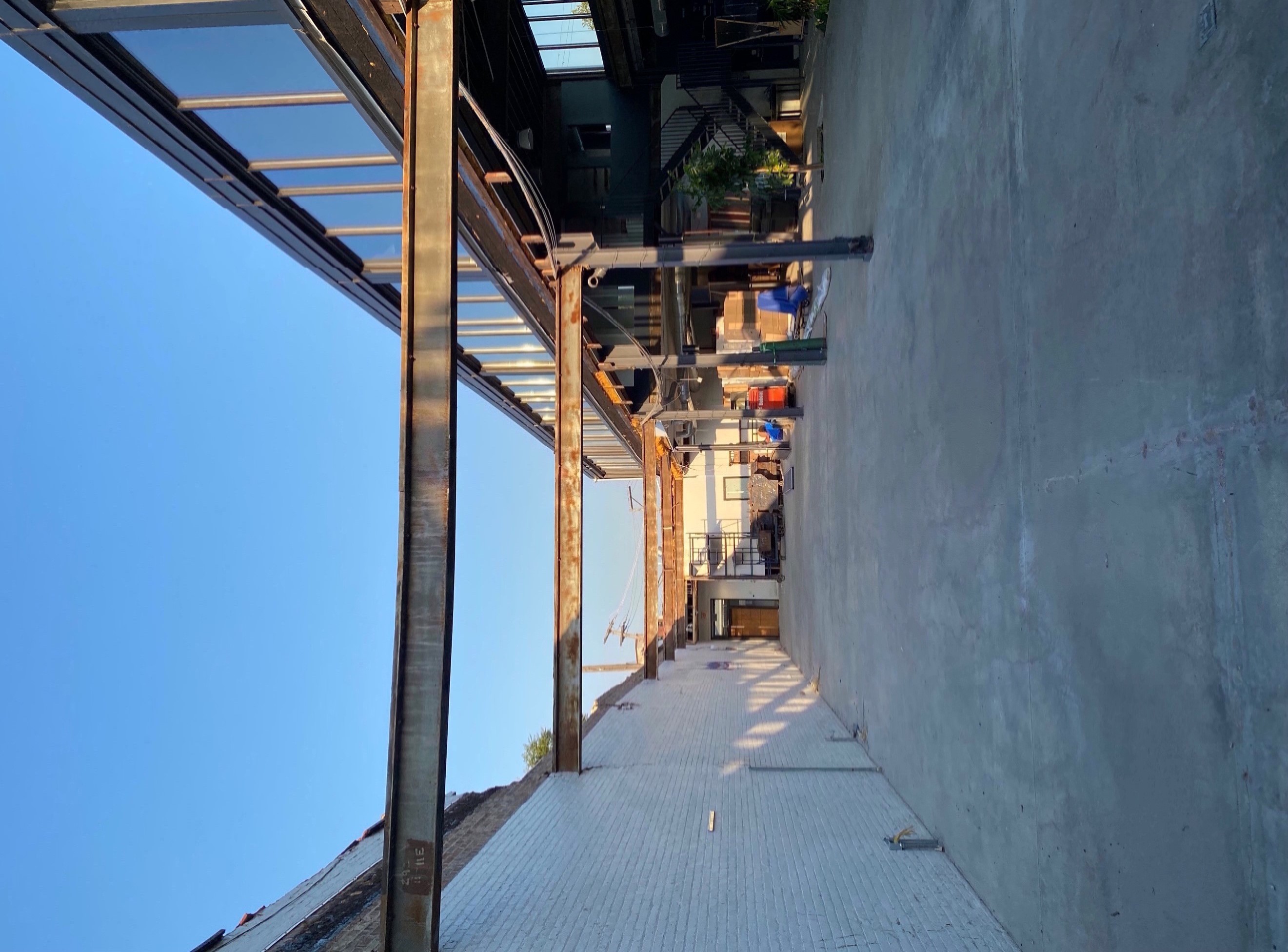 View of missing roof and beautiful view of blue sky from inside damaged office space. 