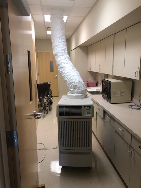 A spot cooler blowing conditioned air into the hallway of a hospital. 