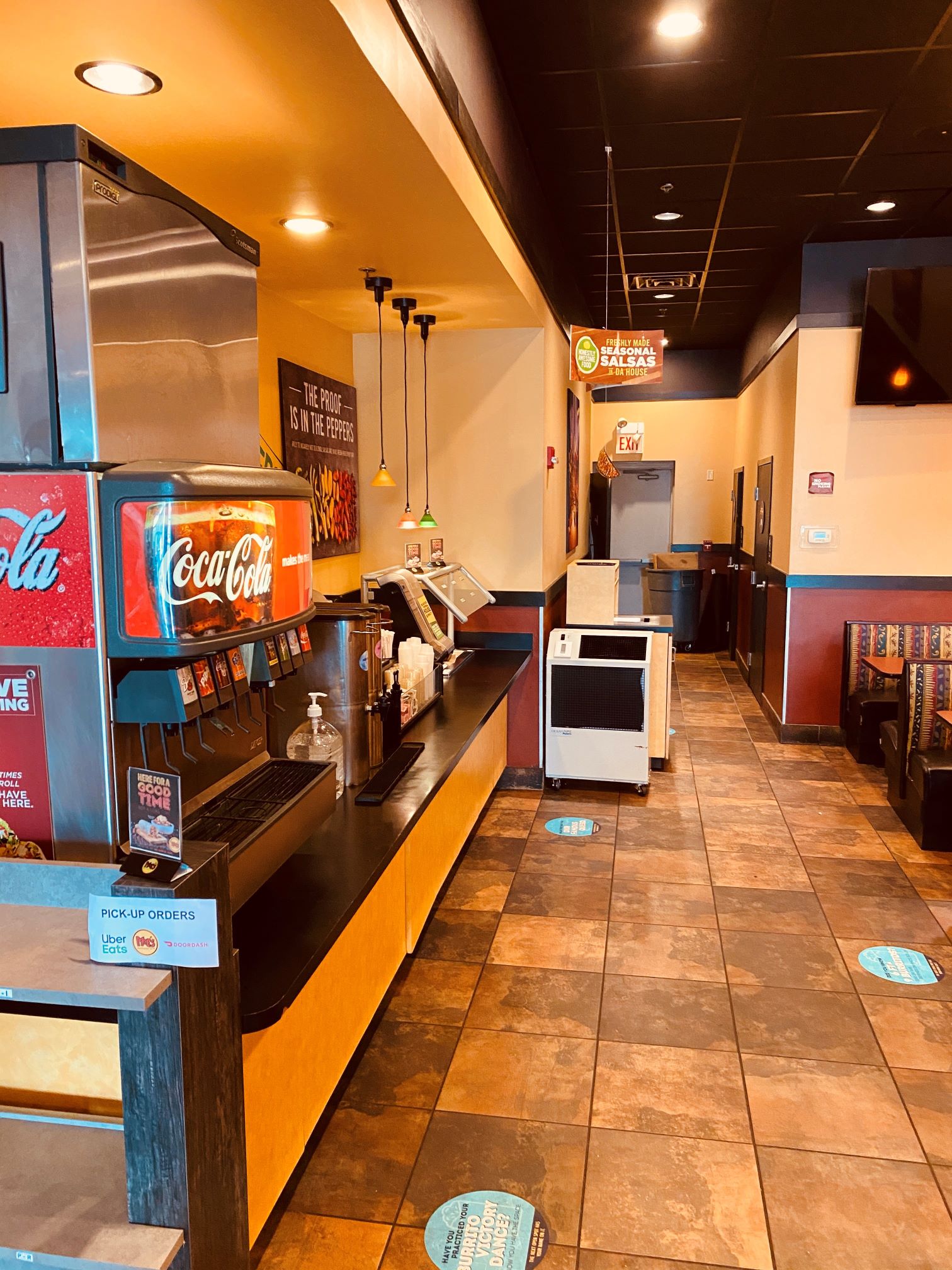 A fast-food restaurant with an air rental near the condiment counter spot cooling the area.  